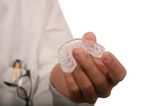 A dentist holds a mouthguard | Teeth Grinding Treatment in Columbia IL