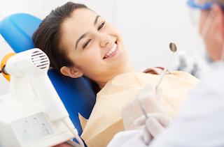 A woman smiles in the dental chair | Root Canal Treatment Columbia IL